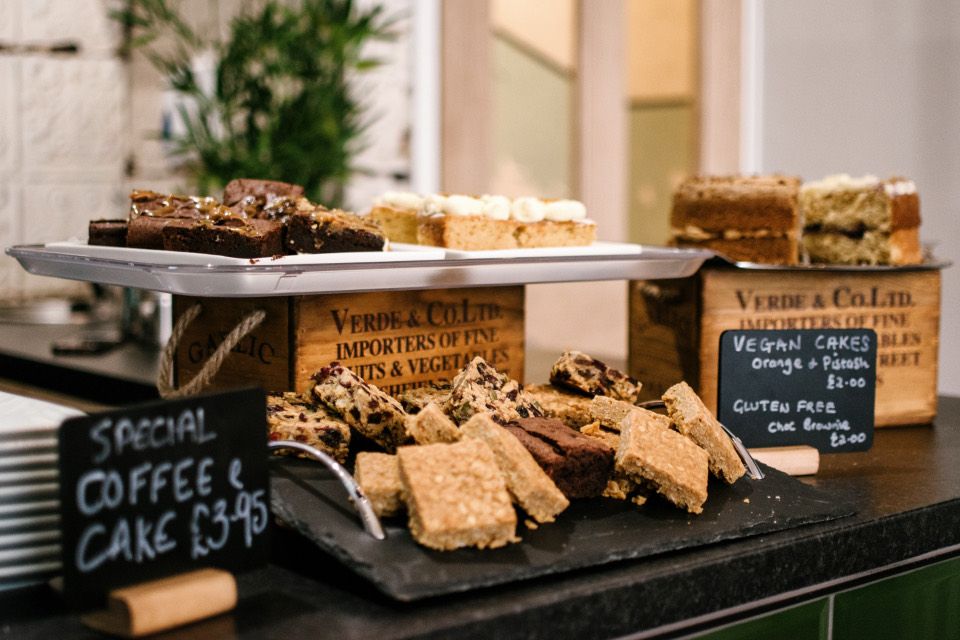 Kuchen, Brownies und Riegel auf Etageren und einer Schieferplatte an der Café-Theke